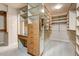 Spacious walk-in closet featuring custom shelving, cabinets, drawers and a central mirror at 4856 E Cheryl Dr, Paradise Valley, AZ 85253