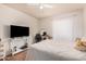 Bright bedroom features a ceiling fan, tv, and a decorative vanity at 5101 W Purdue Ave, Glendale, AZ 85302