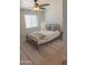A bright bedroom with a ceiling fan, white bedding, neutral colors, and a patterned rug on wood floors at 5102 W Whispering Wind Dr, Glendale, AZ 85310