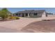 Single story home with white painted brick, a dark roof and mature landscaping on a sunny day at 5102 W Whispering Wind Dr, Glendale, AZ 85310