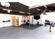 Custom home garage with fitness equipment, television, sauna, and motorcycle at 5102 W Whispering Wind Dr, Glendale, AZ 85310