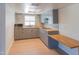 Well-lit kitchen with grey cabinets, wood countertop and backsplash, and a window above the sink at 5102 W Whispering Wind Dr, Glendale, AZ 85310