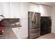 Modern kitchen featuring white cabinets, stainless steel appliances and a laundry area at 5102 W Whispering Wind Dr, Glendale, AZ 85310