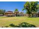 Spacious backyard featuring a gazebo, grass, shed, and mature trees at 5127 W Dobbins Rd, Laveen, AZ 85339
