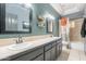 Bathroom featuring double vanity, framed mirrors, and shower/tub combo with decorative shower curtain at 5127 W Dobbins Rd, Laveen, AZ 85339