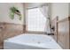 Bright bathroom with a white soaking tub set below a privacy block window with decorative plants at 5127 W Dobbins Rd, Laveen, AZ 85339