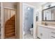 A bathroom with white cabinets, soaking tub, and an entrance to a wooden stairway at 5127 W Dobbins Rd, Laveen, AZ 85339
