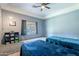 This is a bedroom with a ceiling fan, tray ceiling, and two twin beds at 5127 W Dobbins Rd, Laveen, AZ 85339