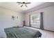 This bedroom boasts a ceiling fan, tile flooring, and a large window offering a view to the outside at 5127 W Dobbins Rd, Laveen, AZ 85339