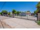 Long driveway ending at a wrought-iron security gate and gray stucco wall at 5127 W Dobbins Rd, Laveen, AZ 85339