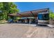Exterior view of the garage and covered area with trucks, RVs, and car lift at 5127 W Dobbins Rd, Laveen, AZ 85339