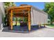 An eye-level view of a wooden gazebo featuring roll-down shades for privacy, adjacent to the main house at 5127 W Dobbins Rd, Laveen, AZ 85339