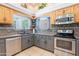 A view of a modern kitchen with stainless steel appliances, gray countertops and wood cabinets at 5127 W Dobbins Rd, Laveen, AZ 85339