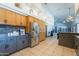 Spacious kitchen with stainless steel appliances, tile floors, wooden cabinets, and gray lower cabinets at 5127 W Dobbins Rd, Laveen, AZ 85339