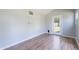 An airy room featuring laminate floors, light grey walls, and an exterior door leading to the property's backyard at 5127 W Dobbins Rd, Laveen, AZ 85339