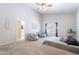 Bright, carpeted primary bedroom with bean bag chairs, neutral decor, and a ceiling fan at 5127 W Dobbins Rd, Laveen, AZ 85339