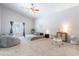 A bright bedroom with a ceiling fan, carpet flooring and a window for natural light at 5127 W Dobbins Rd, Laveen, AZ 85339