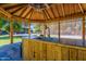 Outdoor kitchen and eating area under a wooden pergola with fans and sink, perfect for entertaining at 5127 W Dobbins Rd, Laveen, AZ 85339