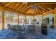 Inviting outdoor seating area under a wooden pergola, complete with comfortable couches and a built-in outdoor kitchen at 5127 W Dobbins Rd, Laveen, AZ 85339