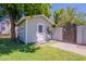 Charming shed with a white door and lush landscaping, perfect for a backyard retreat at 5127 W Dobbins Rd, Laveen, AZ 85339