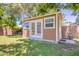 Charming shed with double doors and surrounding green grass, creating a peaceful backyard retreat at 5127 W Dobbins Rd, Laveen, AZ 85339