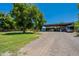 Lush lawn featuring mature tree and spacious covered parking for trucks and RVs at 5127 W Dobbins Rd, Laveen, AZ 85339
