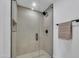 Modern shower with a glass door, black fixtures, and neutral tiling for a luxurious experience at 6233 E Pinchot Ave, Scottsdale, AZ 85251