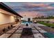Beautiful backyard design features pool, travertine patio, fire feature, and desert landscaping at 6401 E Larkspur Dr, Scottsdale, AZ 85254