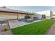 A manicured backyard features a pool, fireplace, artificial turf, and stone pavers at 6401 E Larkspur Dr, Scottsdale, AZ 85254