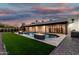 Striking backyard includes pool with fire feature, a covered patio, and lush artificial lawn at 6401 E Larkspur Dr, Scottsdale, AZ 85254