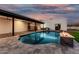 Gorgeous backyard featuring a modern pool, covered patio, outdoor kitchen, and fire feature at 6401 E Larkspur Dr, Scottsdale, AZ 85254