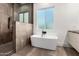 Elegant bathroom with a standalone tub, tiled shower, and large window providing natural light at 6401 E Larkspur Dr, Scottsdale, AZ 85254