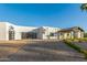 Modern home with a circular paver driveway and a porte cochere, creating an inviting entrance and maximizing space at 6401 E Larkspur Dr, Scottsdale, AZ 85254