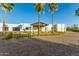Striking modern home with a paver driveway, palm trees, and a porte cochere, offering a grand entrance at 6401 E Larkspur Dr, Scottsdale, AZ 85254
