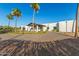 Beautiful modern home with a porte cochere and a circular paver driveway, framed by mature palm trees and desert landscaping at 6401 E Larkspur Dr, Scottsdale, AZ 85254