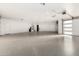Spacious three-car garage featuring an epoxy floor, overhead doors with windows, and a utility closet at 6401 E Larkspur Dr, Scottsdale, AZ 85254