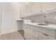 Laundry room with modern cabinets, countertop, and stainless steel sink and faucet at 6401 E Larkspur Dr, Scottsdale, AZ 85254
