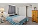 Carpeted bedroom featuring a gray curtain, a bed with blue pattern, and closet with sliding doors at 701 S Dobson Rd # 438, Mesa, AZ 85202