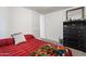Carpeted bedroom featuring a bed with red cover and sliding door closet at 701 S Dobson Rd # 438, Mesa, AZ 85202