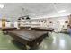 Large billiard room features multiple pool tables covered with protective tarps, ample lighting and cozy seating at 701 S Dobson Rd # 438, Mesa, AZ 85202
