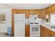 Practical kitchen equipped with white appliances, wood cabinets, and ample storage space at 701 S Dobson Rd # 438, Mesa, AZ 85202