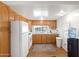 Well-lit kitchen featuring white appliances, wood cabinetry, and a window above the sink at 701 S Dobson Rd # 438, Mesa, AZ 85202