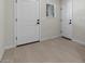 The tiled entryway has two white doors with black hardware and a small window at 7448 S 75Th Ln, Laveen, AZ 85339