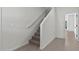 Modern staircase with carpeted steps, white walls, and tile flooring on the landing at 7448 S 75Th Ln, Laveen, AZ 85339