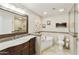 Luxurious bathroom with a soaking tub, a dark wood vanity, and neutral toned tiling at 922 S Ember Cir, Mesa, AZ 85208