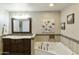 Bathroom showcasing a soaking tub, a dark wood vanity, and neutral toned tiling at 922 S Ember Cir, Mesa, AZ 85208