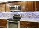Stove-level view of updated kitchen appliances and decor, including stainless steel range and microwave at 922 S Ember Cir, Mesa, AZ 85208