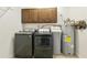 Functional laundry area with washer, dryer, and storage cabinets at 922 S Ember Cir, Mesa, AZ 85208