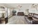 Spacious living room featuring wood-look floors, leather couches, and abundant natural light at 922 S Ember Cir, Mesa, AZ 85208