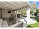 Inviting covered patio with an outdoor kitchen, comfortable seating, and a mounted television at 922 S Ember Cir, Mesa, AZ 85208